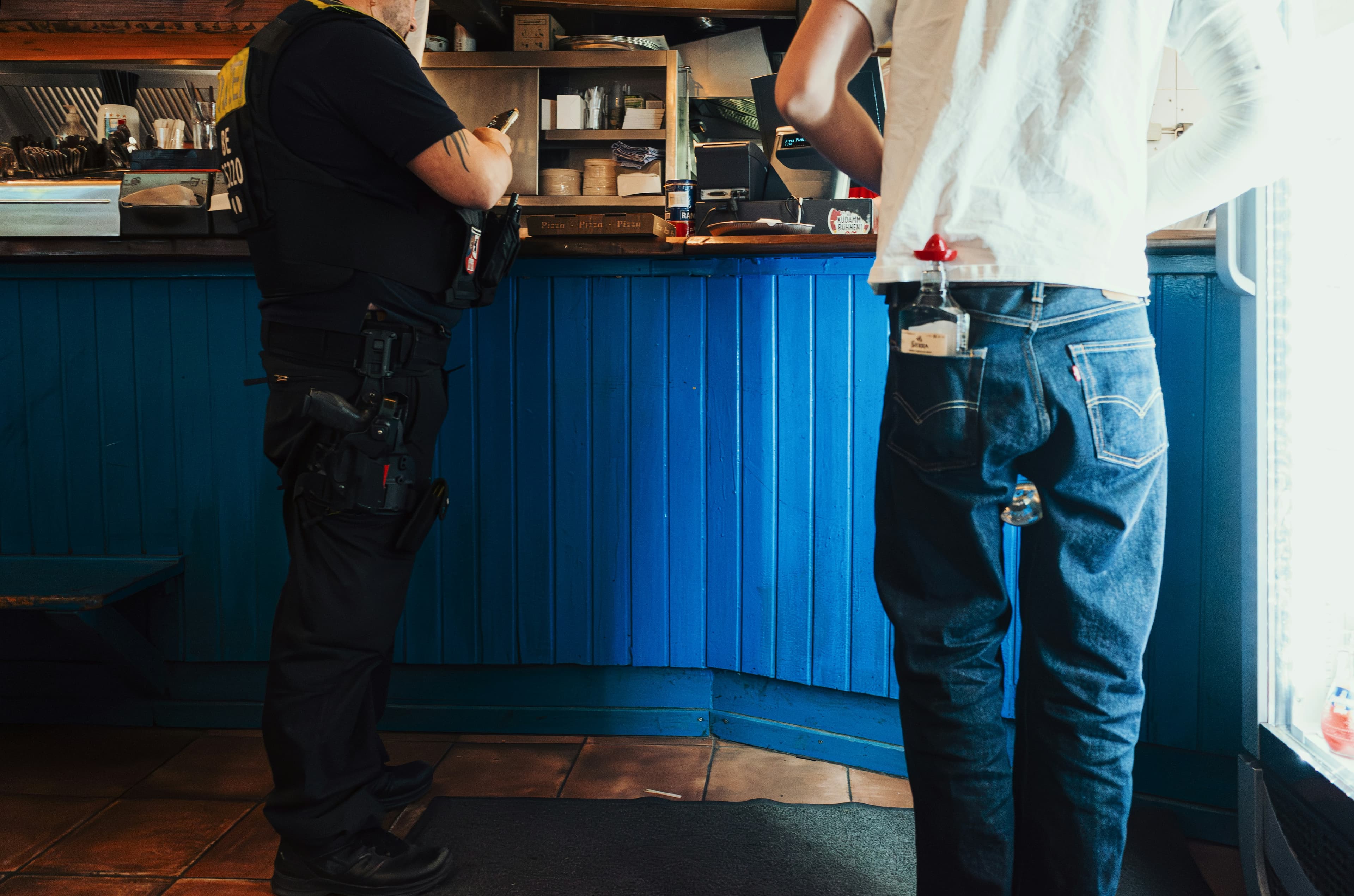 Two people standing at a blue bar counter
