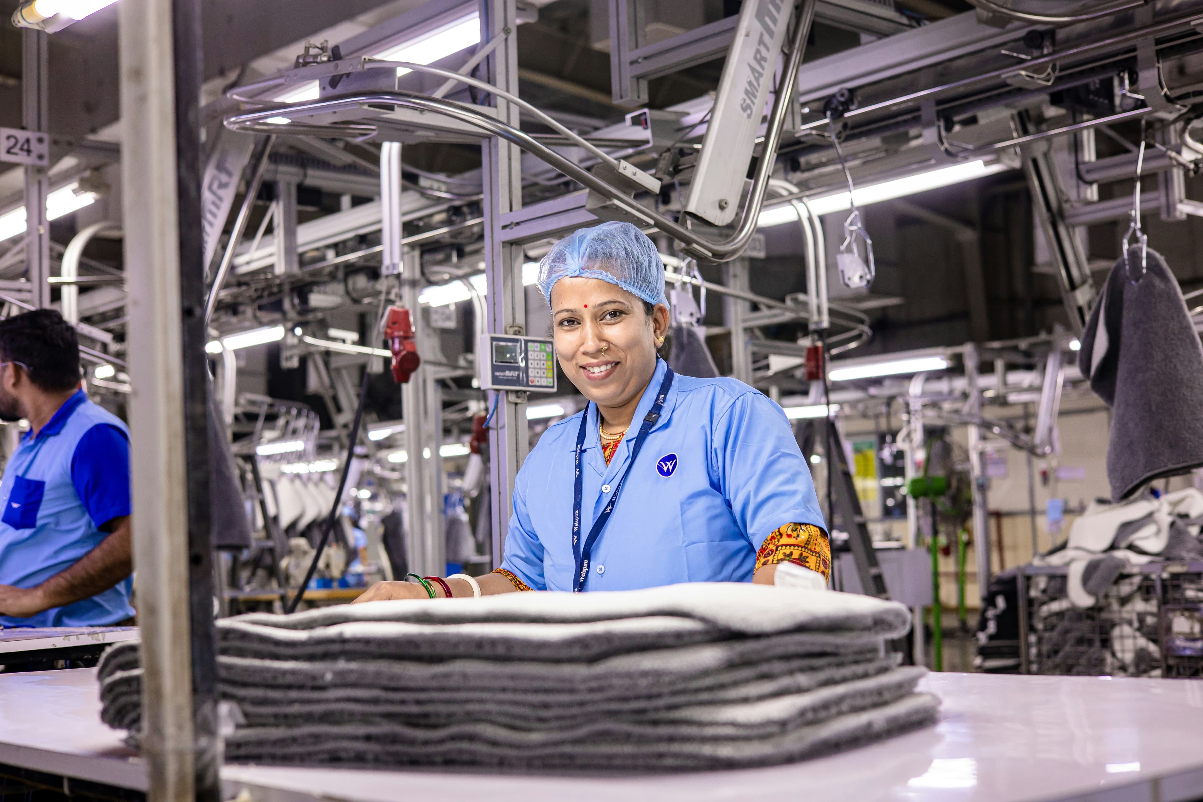 Woman works in a textile factory, smiling