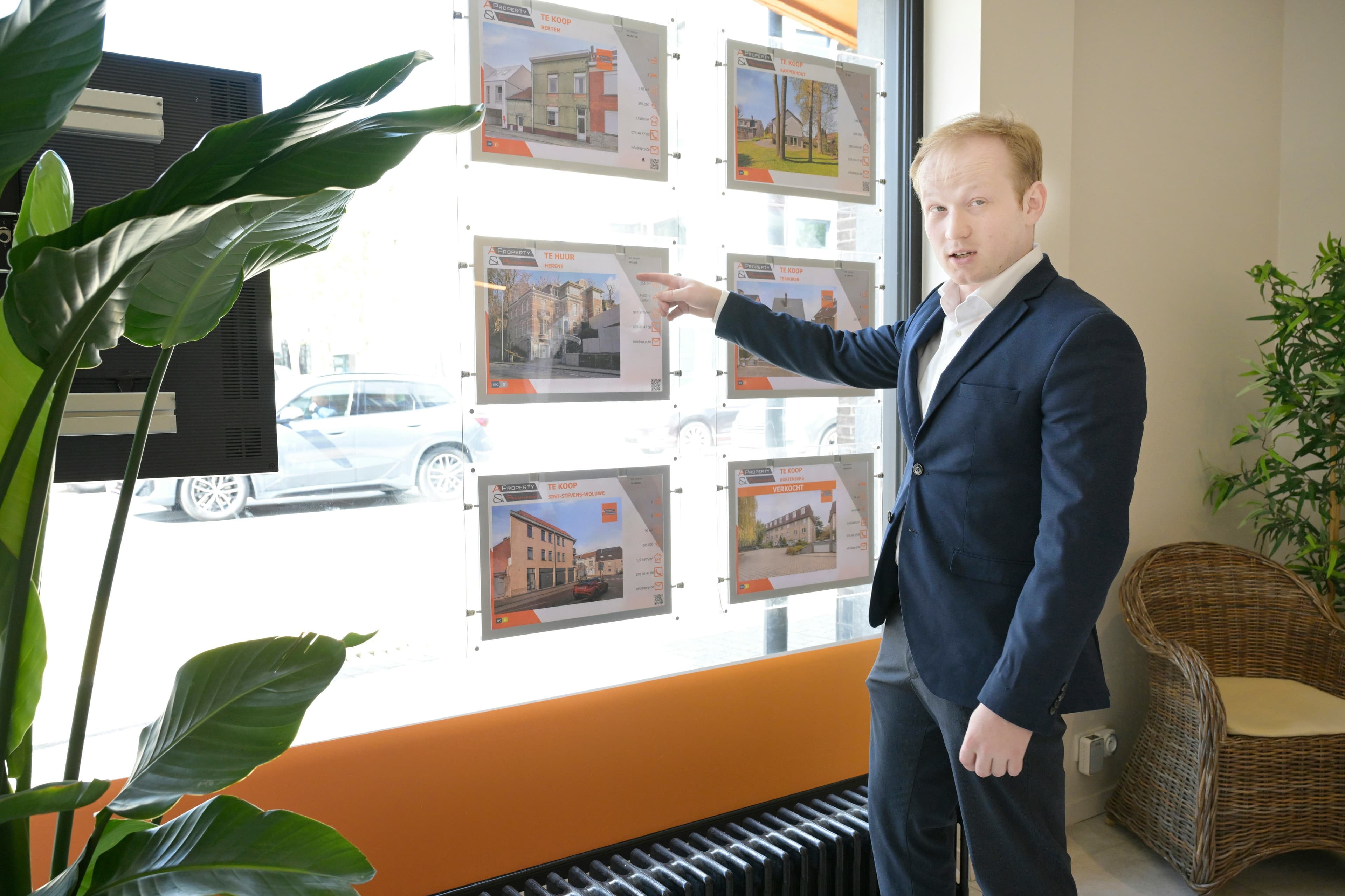 Real estate agent pointing at property listings in office window
