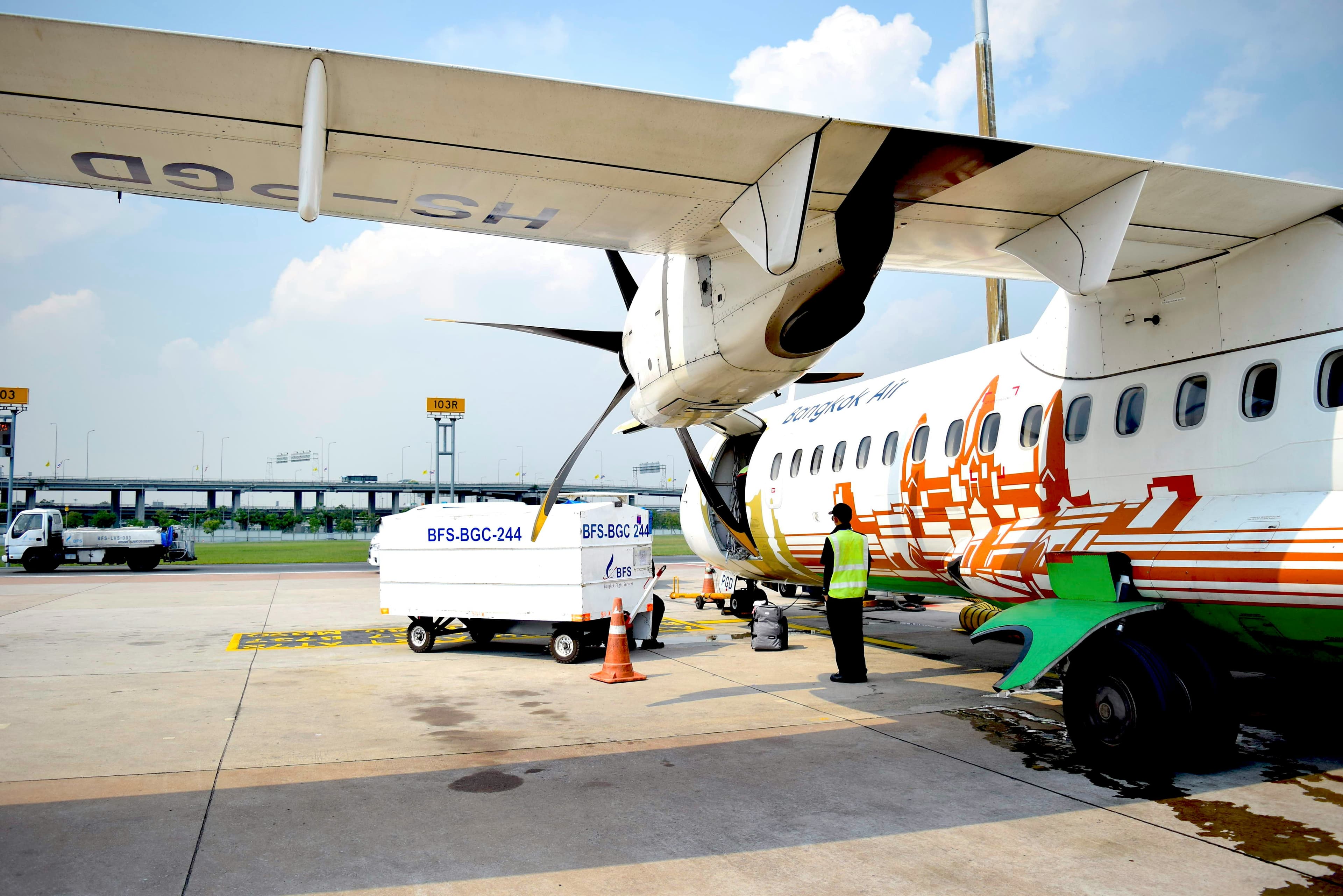 a man standing next to an airplane on a tarmac