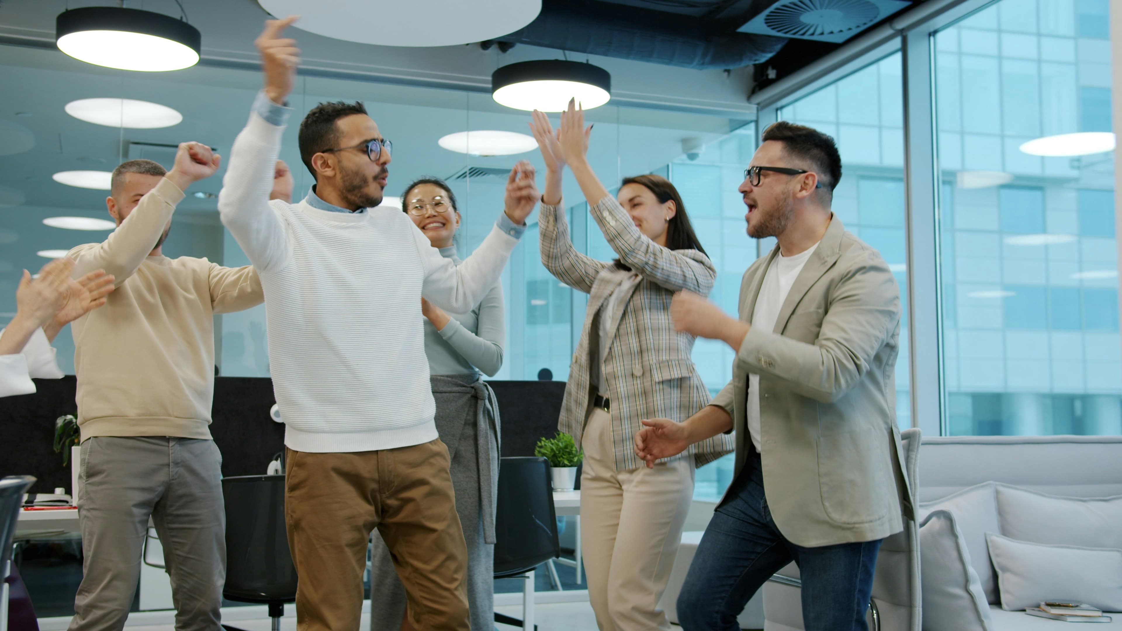 A diverse group of colleagues celebrating success in an office