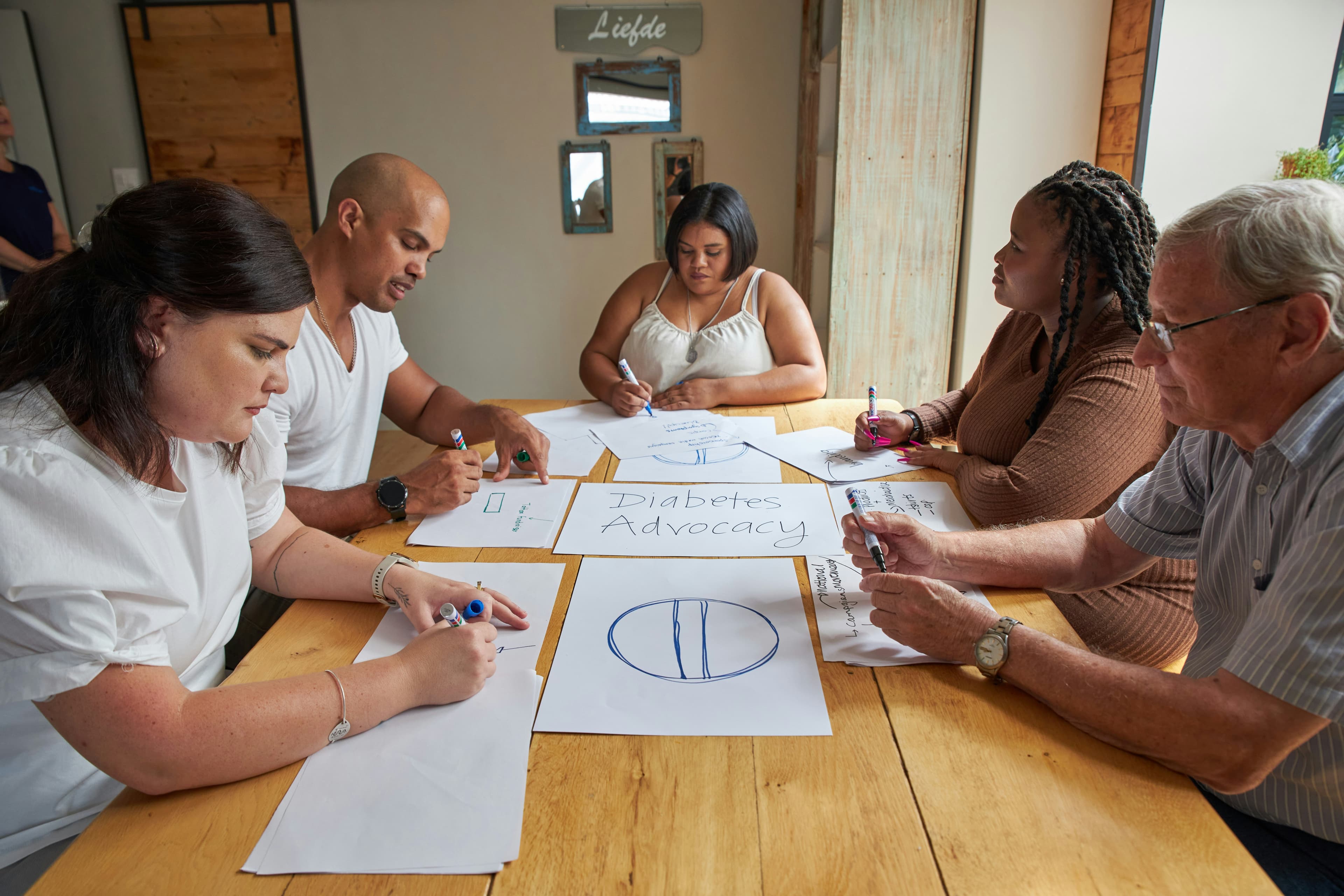 People are drawing on paper during a meeting