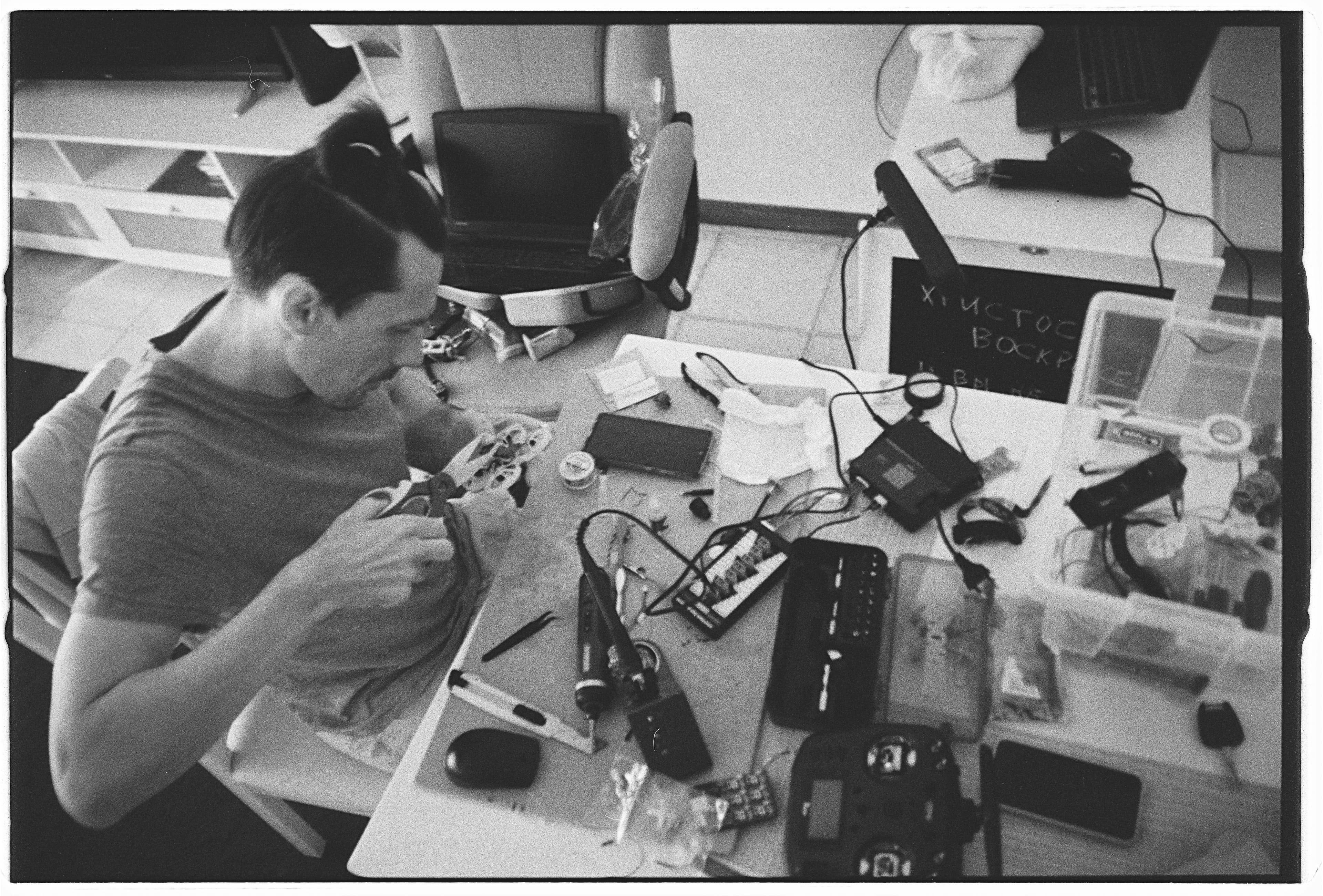Man working on electronics at a cluttered desk