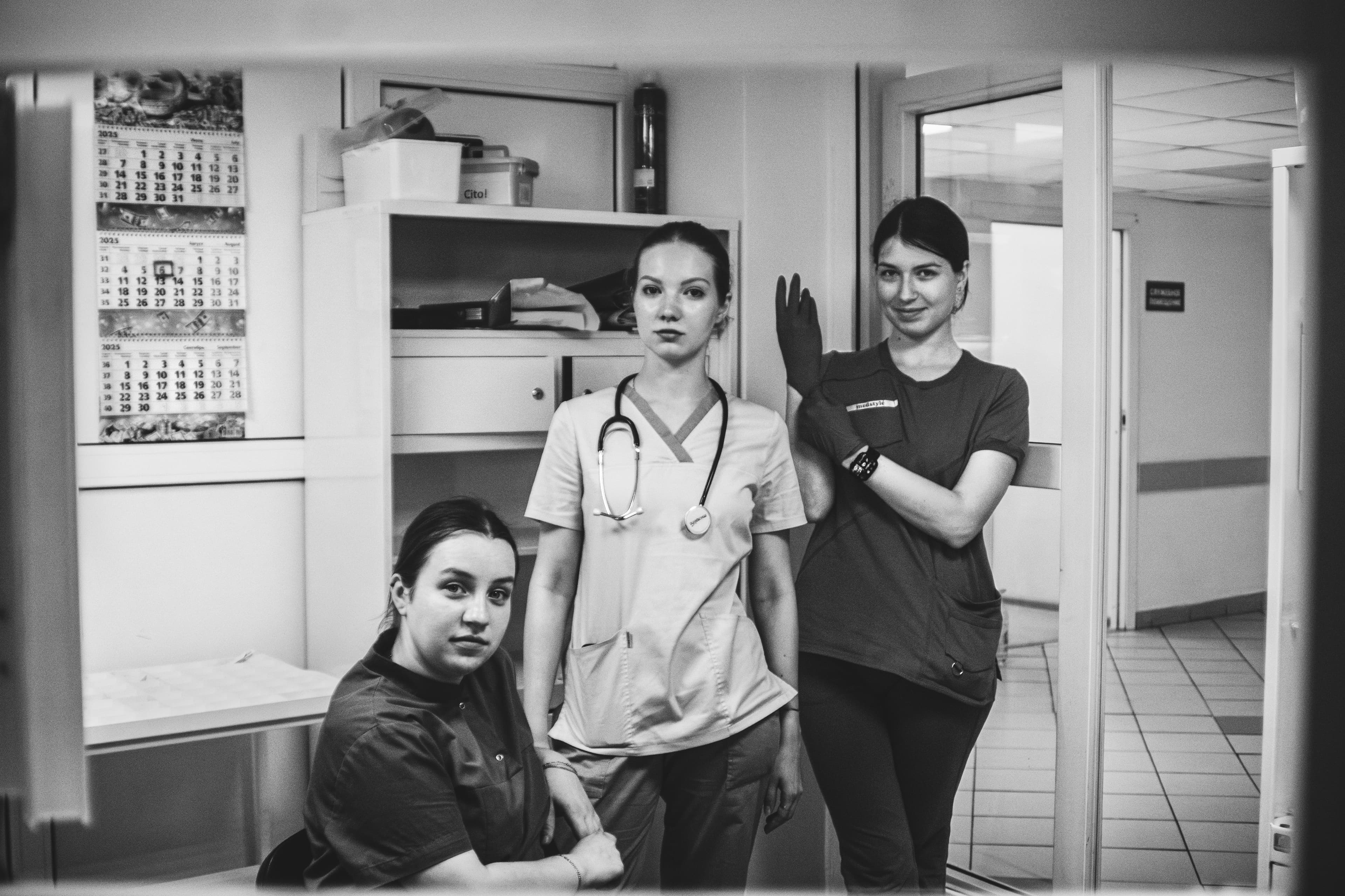 Three medical professionals posing in a hospital hallway