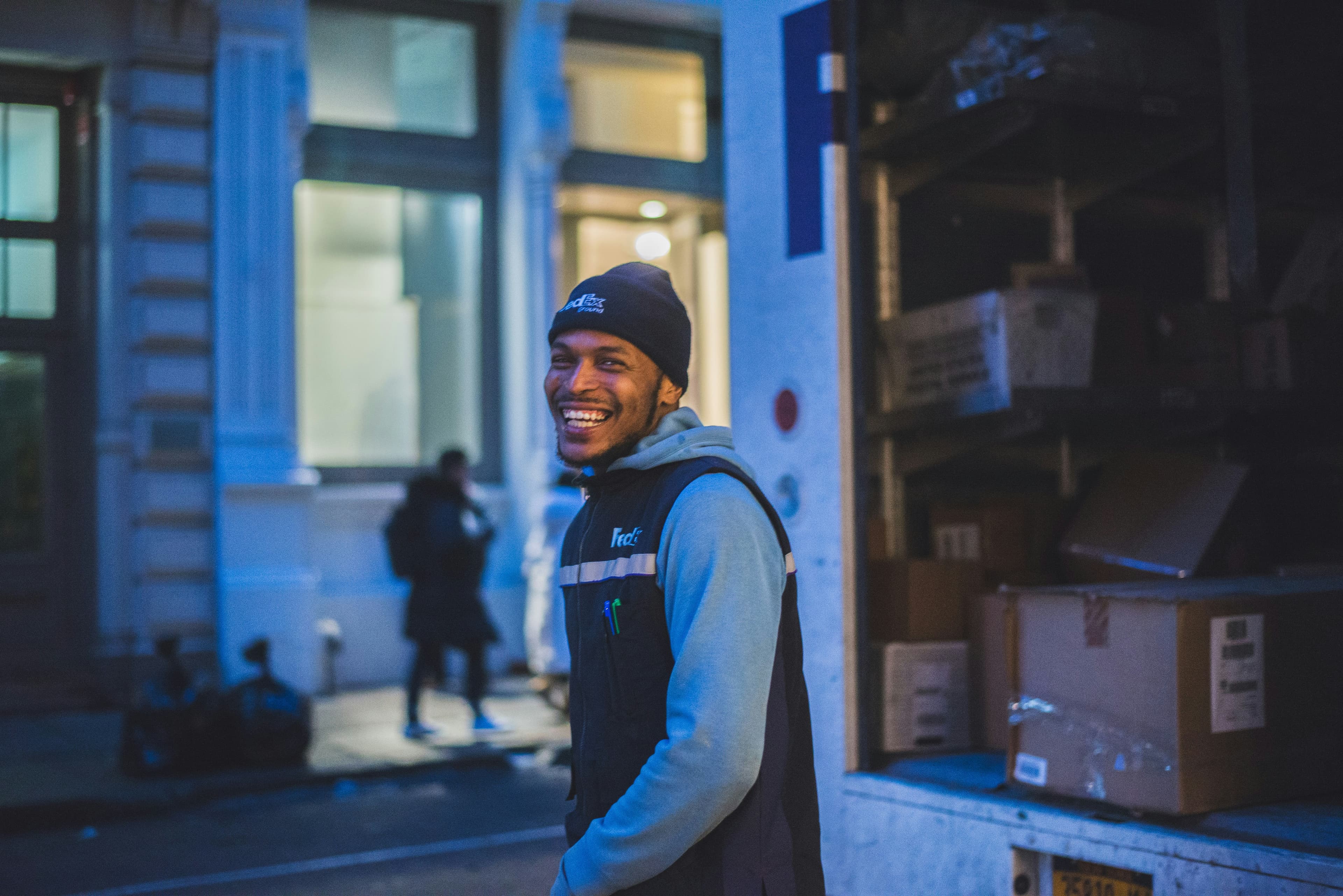 Smiling delivery driver standing at an open freight truck